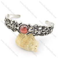 steel skull bangle with round clear red stone b002494
